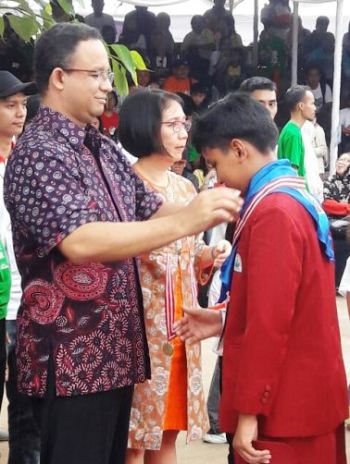 Siswa SD Unggulan AL-YA'LU Dies Haditsa Putra Nursadih menerima pengalungan medali emas Olimpiade Sains Kuark level III dari Mendikbud Prof. Anies Rasyid Baswedan, Ph.D.
